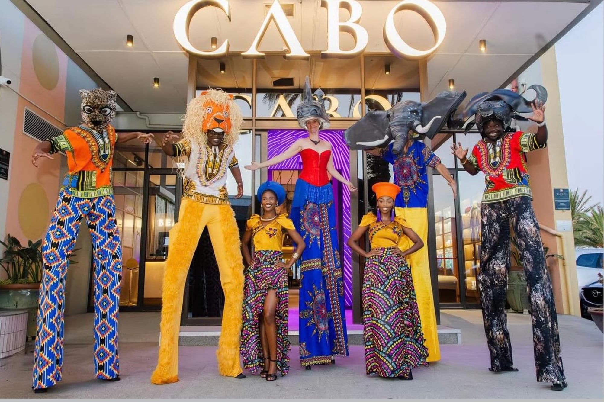 Stilt walkers and African dancers performing at Cabo Beach Club