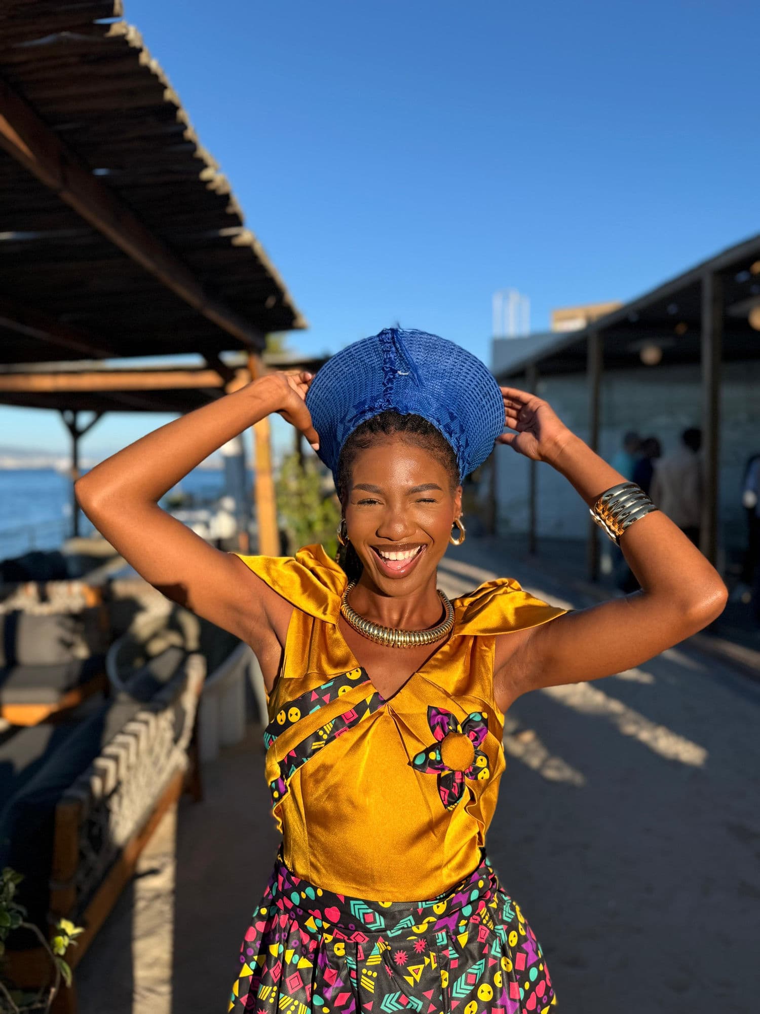 Performer in traditional African attire laughing at a Cape Town beach venue