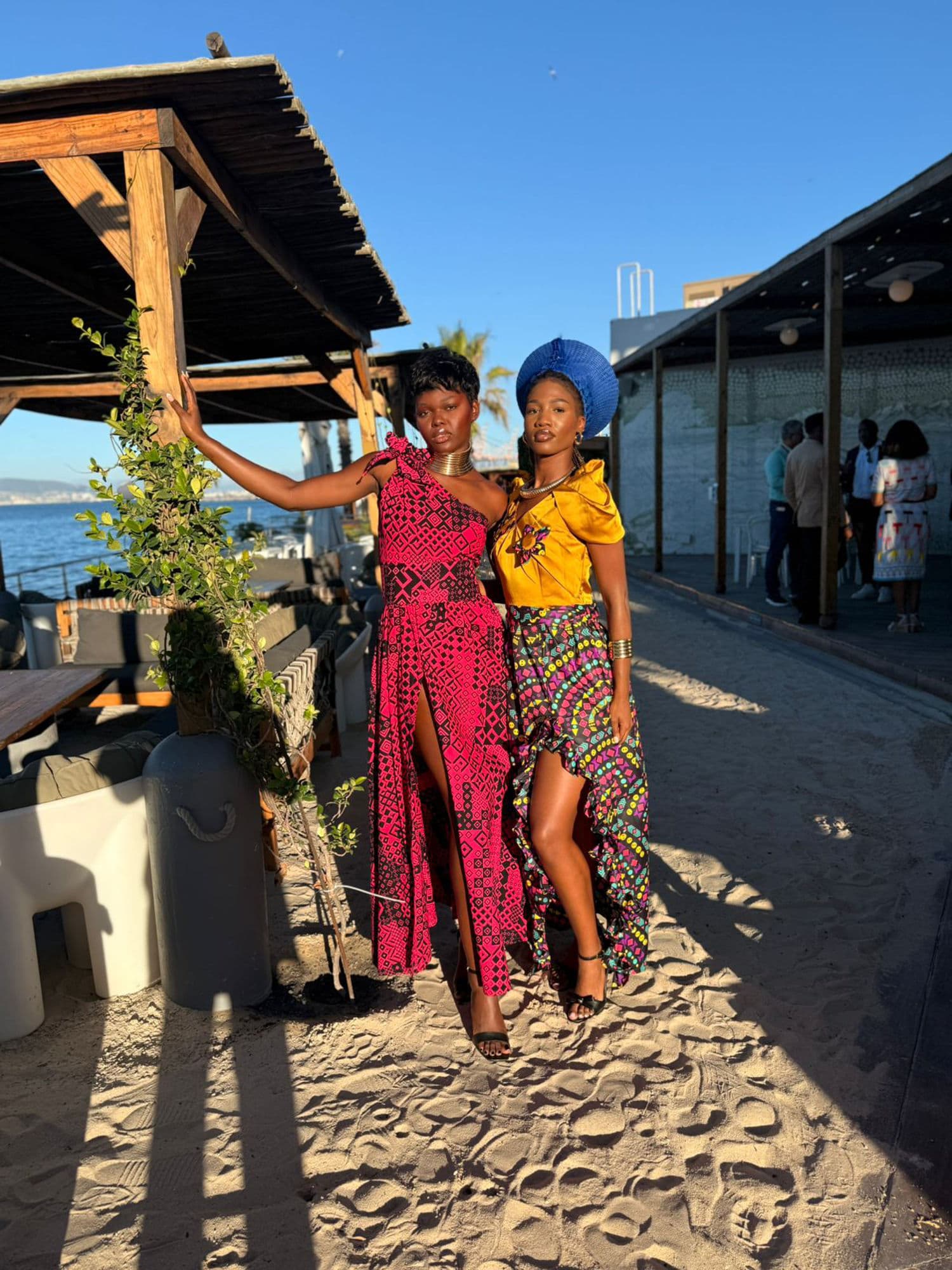 Two performers in African attire at a Cape Town beach at sunset